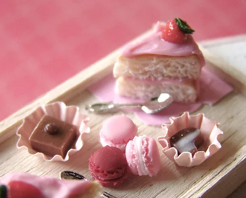 Dessert assortment featuring pink pastries, chocolates, and macarons.