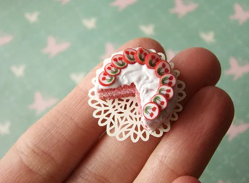 A handmade miniature cake on a decorative doily held in a hand.