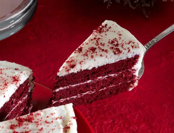 Red velvet cake slice on a red background.