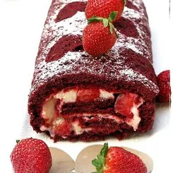 Red velvet roll cake garnished with fresh strawberries.