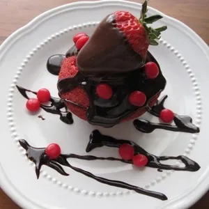 Chocolate-covered dessert topped with strawberries and raspberries.
