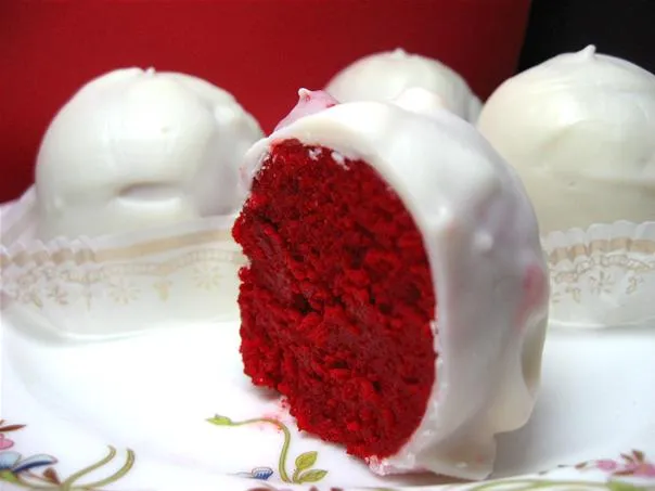 Red velvet cake balls covered in white chocolate.