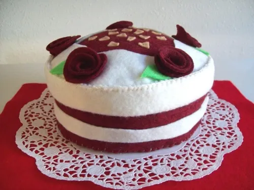 Decorative faux cake with red and white layers and flower embellishments.
