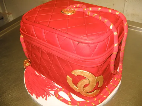 Red quilted handbag-shaped cake with gold detailing.