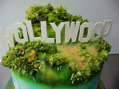 Hollywood-themed cake topped with green frosting and decorative elements.