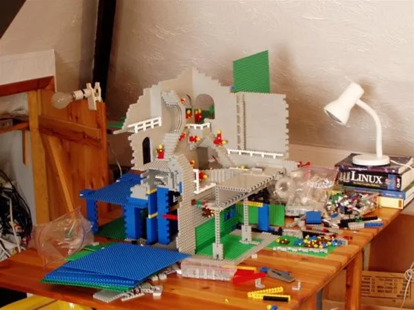 Lego model displayed on a wooden table with various building pieces.