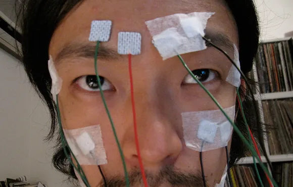 Person undergoing a medical test with electrodes attached to their face.