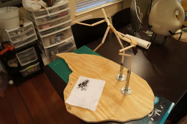 Artistic model stand with wooden base and sketch.