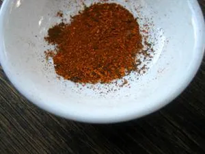 Bowl of mixed spices on a wooden surface.