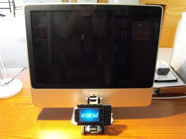 Computer monitor with a smartphone docking station in front.