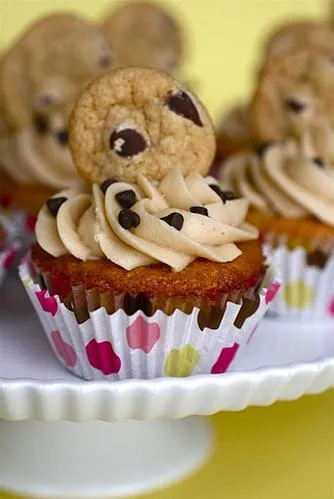 Chocolate chip cookie cupcakes with frosting, topped with mini cookies.