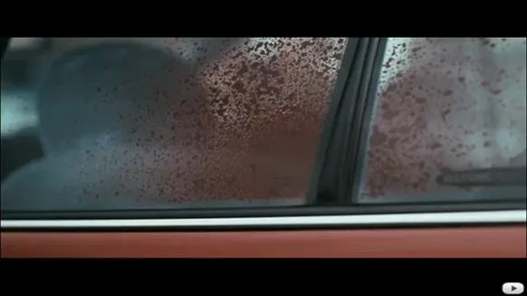 Fogged car window with water droplets.