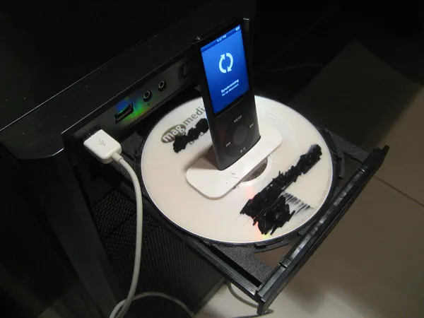 Music player docked on a device with a CD tray.