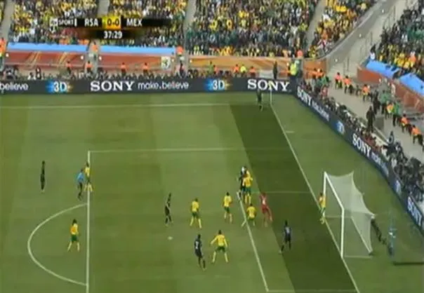 Soccer match in progress with players near the goal line during a corner kick.