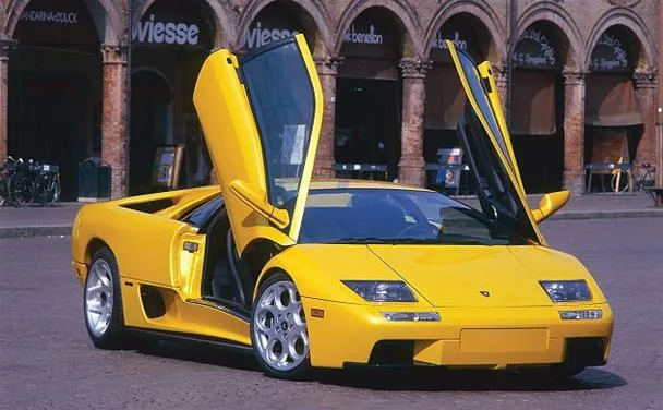 Yellow sports car with gullwing doors in an urban setting.