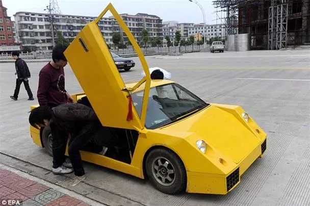 A person inspecting a yellow sports car with its door open.