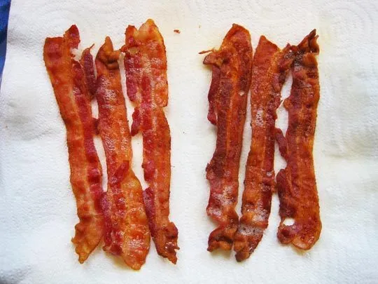 Cooked bacon strips on a paper towel.