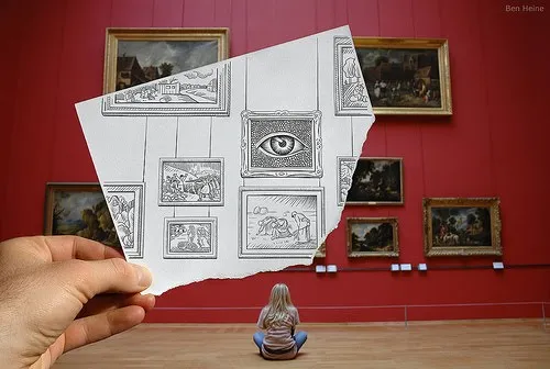 A person sitting in an art gallery holding a sketched image of framed artwork.
