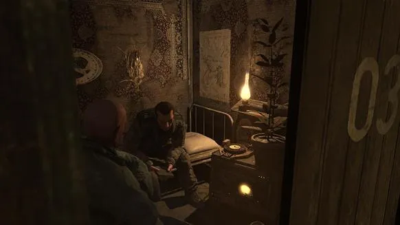 A dimly lit room with a man sitting on a bed, surrounded by books and personal items.