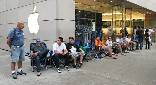 People waiting in line outside an Apple store.