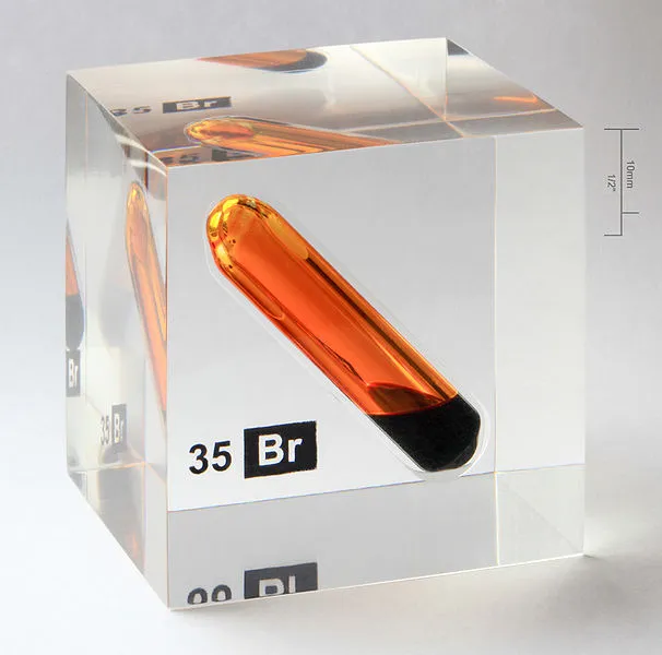 Orange bromine sample in a transparent cube.