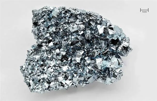 Natural crystal formation of a metallic mineral on a neutral background.
