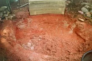 Excavated area of red soil, prepared for construction or landscaping.