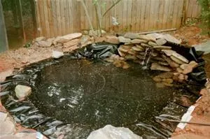 Garden pond surrounded by rocks and landscaping.