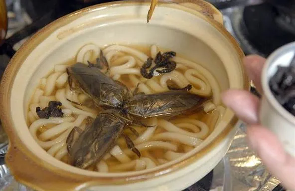Bowl of noodles with seafood and broth.
