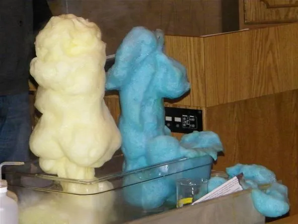 Cotton candy in yellow and blue colors displayed at a fair or event.
