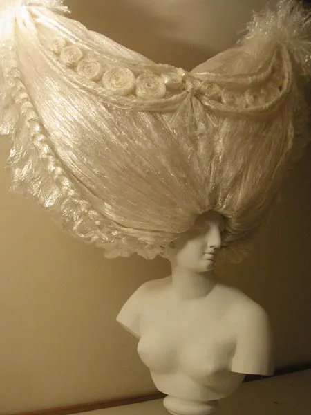 Vintage mannequin showcasing an elaborate white lace garment.