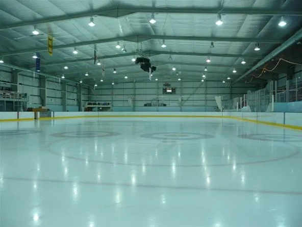Ice skating rink interior with bright lighting.