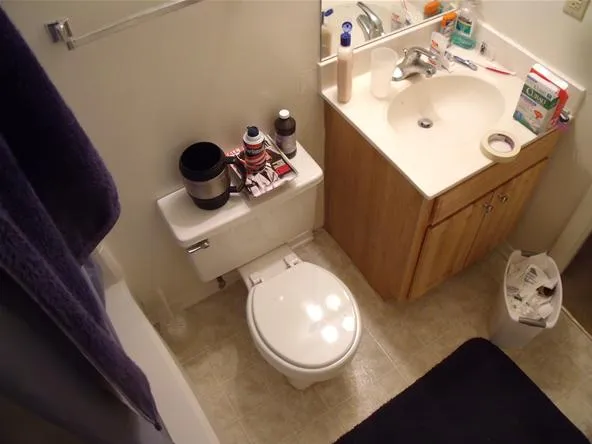 Bathroom with a toilet, sink, and various toiletries.