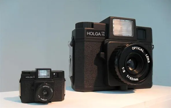 Two cameras side by side, one large and one small, showcasing different designs.