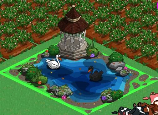 Gazebo with swans and a pond surrounded by flowers and greenery.