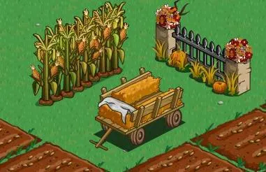 A wooden cart filled with hay surrounded by cornfields and a garden fence.