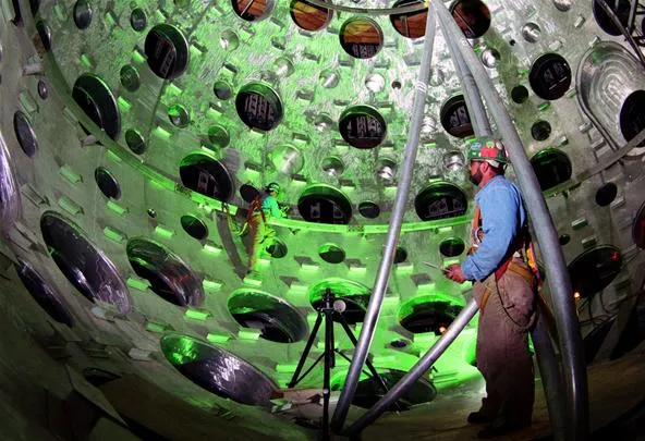 Engineer working on a large industrial structure with green lighting.