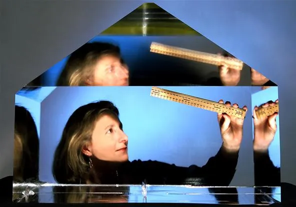 A person examining a geometric shape with a ruler.