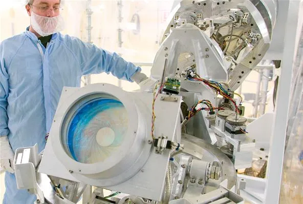 A technician operating advanced machinery in a clean room environment.