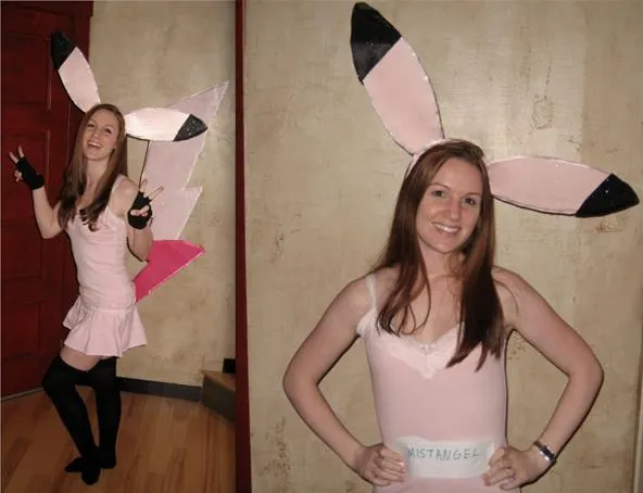 Person in a playful costume with large ears and a tail, posing in front of a wall.