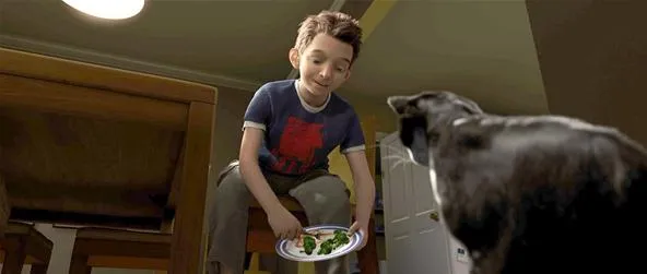 A boy feeding a dog from a plate.