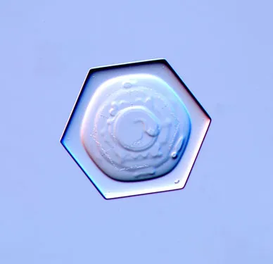 Hexagonal crystal structure on a blue background.