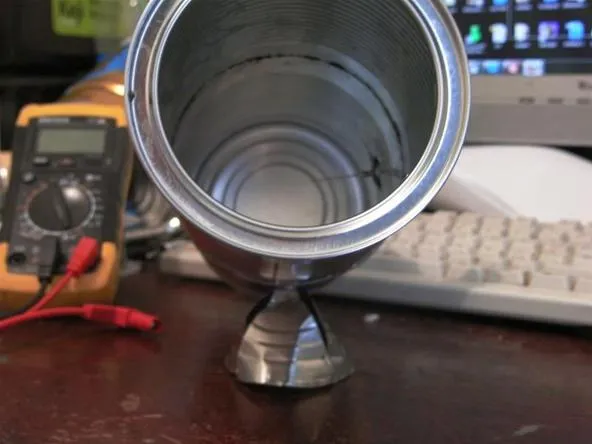 Metal cup or trophy placed on a desk with tools and electronics in the background.