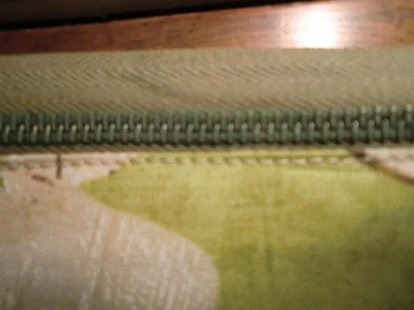 Close-up of a zipper on a textured fabric surface.