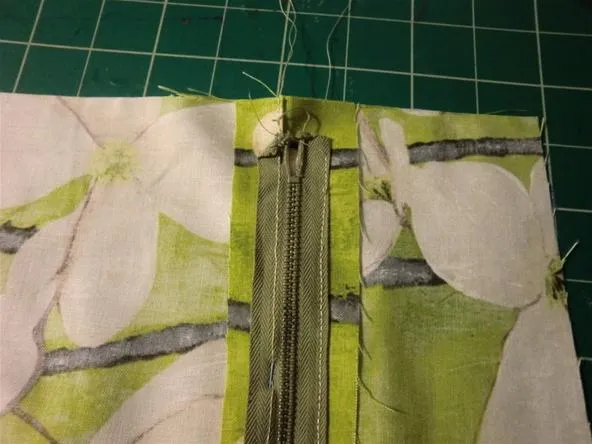 Close-up of a sewing zipper on a floral fabric.