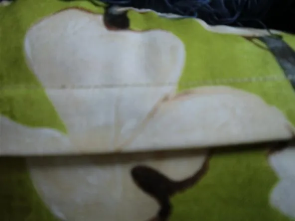 A close-up of a patterned fabric featuring white flowers on a green background.