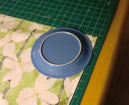Blue plate on a green floral patterned surface.