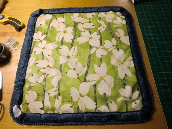 Floral patterned fabric with a green background and denim border.