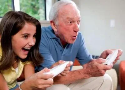 Grandfather and granddaughter enjoying video gaming together.