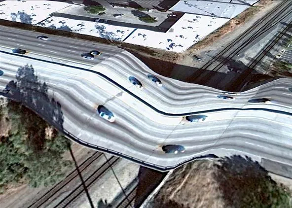 Aerial view of a wavy road with cars driving on it.